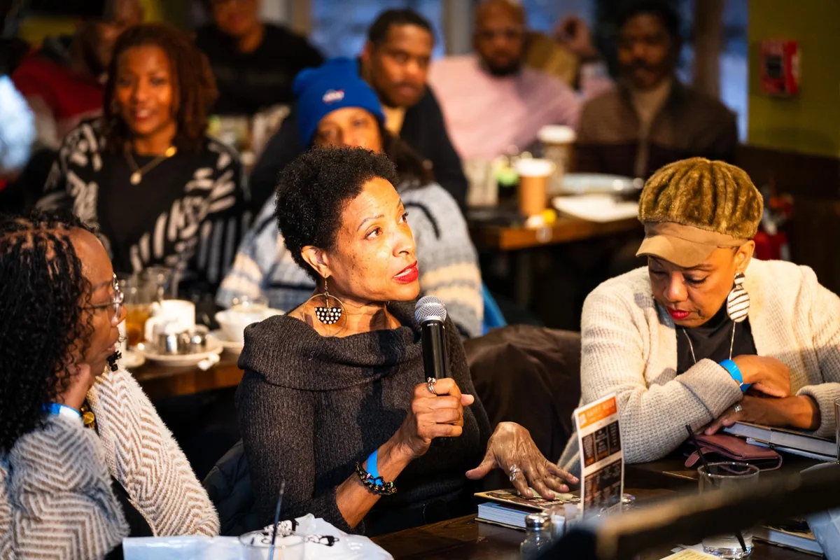 An audience member speaking into a microphone during a community conversation
