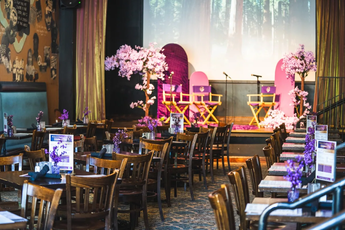 Tables and a flower-decorated stage prepared for an event